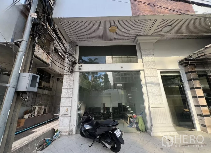 零售空间 出租 - 街边商铺正面，整面玻璃立面与铺装前庭，位于曼谷市中心。
