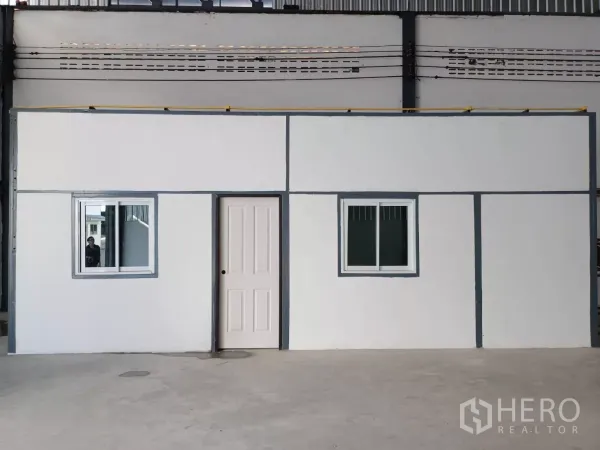 Warehouse for rent in Suan Luang, Bangkok - Close-up of the internal office with two windows and a door inside the warehouse.