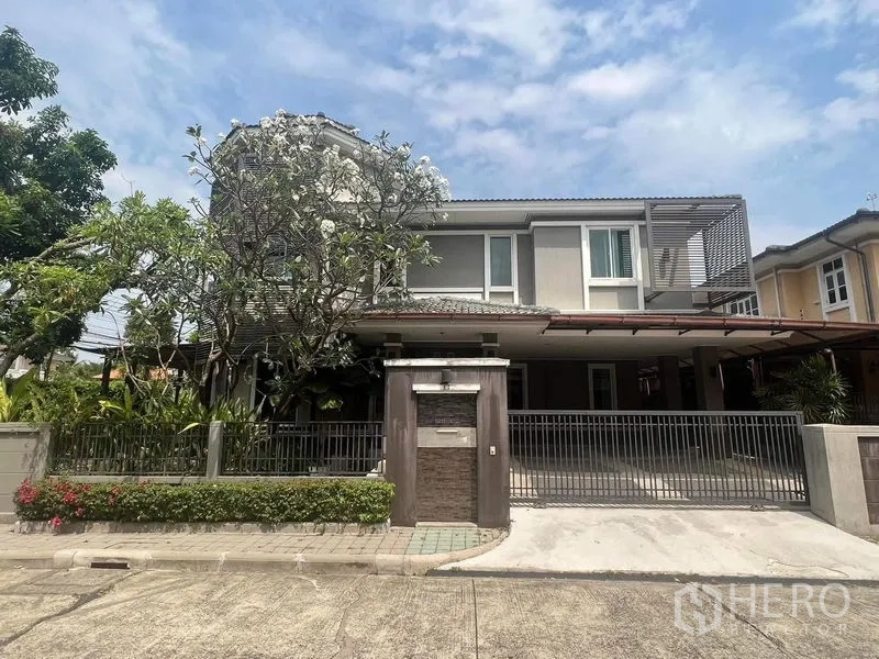 Detached House for rent or sale in Prawet, Bangkok - Modern two-storey detached house with gated driveway, covered carport and mature frangipani tree.