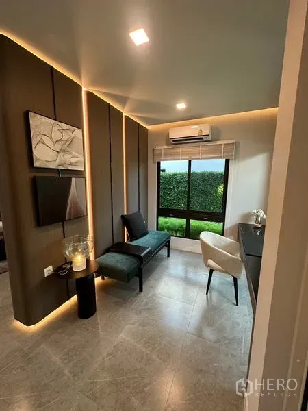 Detached House for rent in Samut Prakan - Compact home office with feature wall lighting, split air-conditioner and a garden-view window.