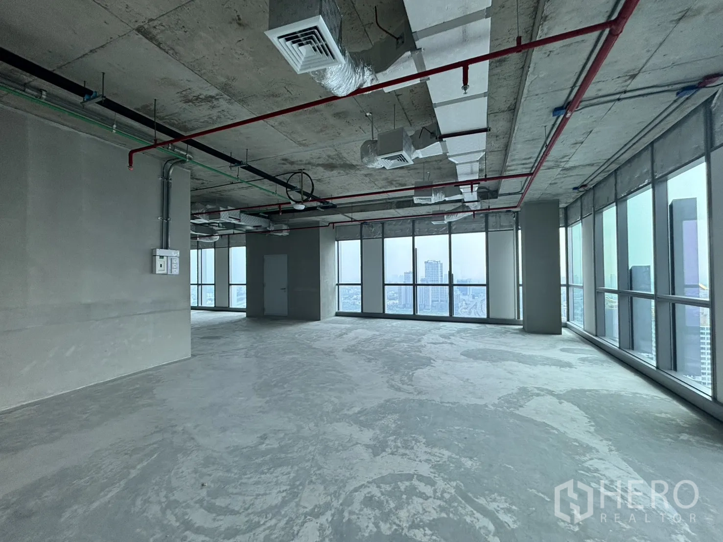 办公空间 出租在Huai Khwang, Bangkok - 毛坯办公楼层，裸顶管线与落地窗俯瞰城市景观。