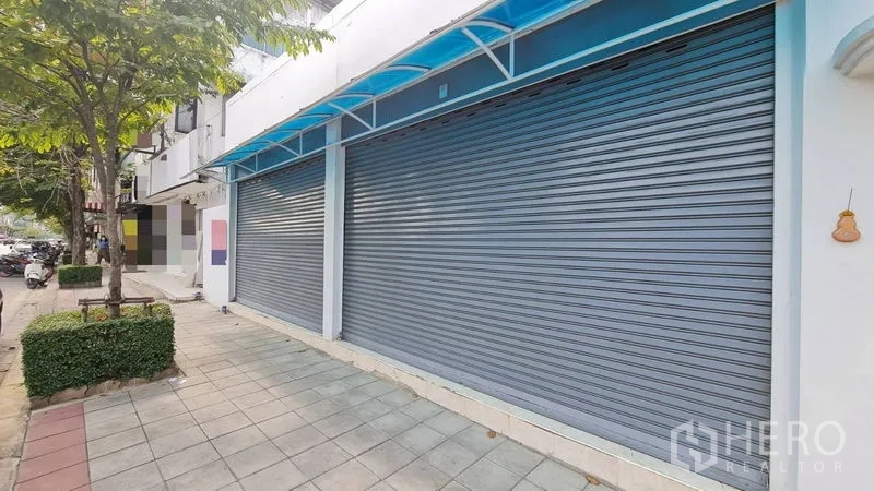 Shophouse for rent - Shophouse exterior with twin roller shutters under blue awning and wide sidewalk