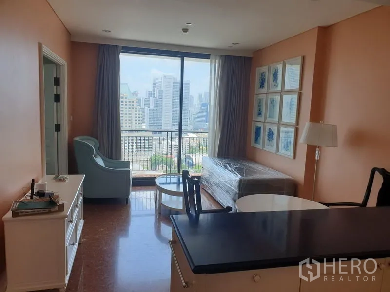 Condominium for rent in Khlong Toei, Bangkok - Bright living area with floor-to-ceiling window, balcony and wide Bangkok skyline view.
