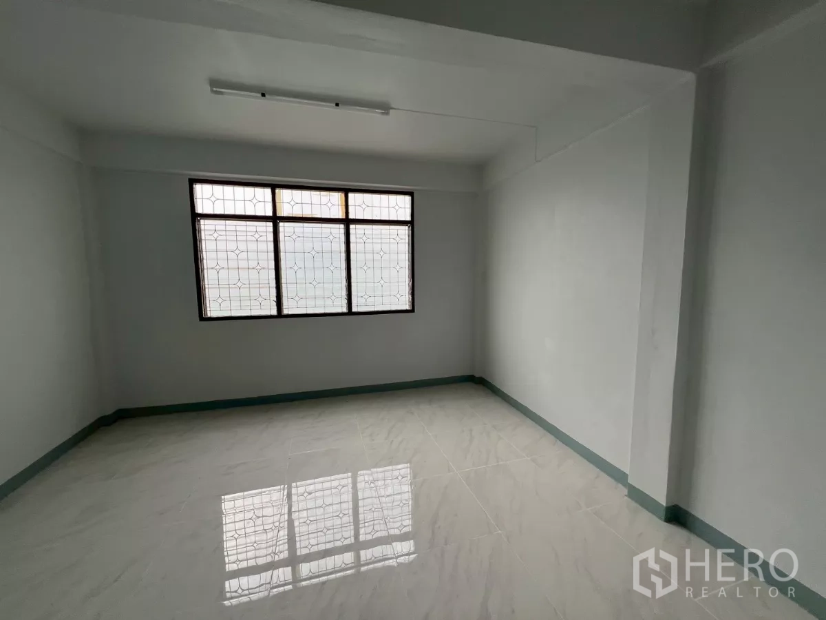 店屋 出租在Khlong Toei, Bangkok - 采光充足的房间，白色亮面地砖与大面积防护窗。