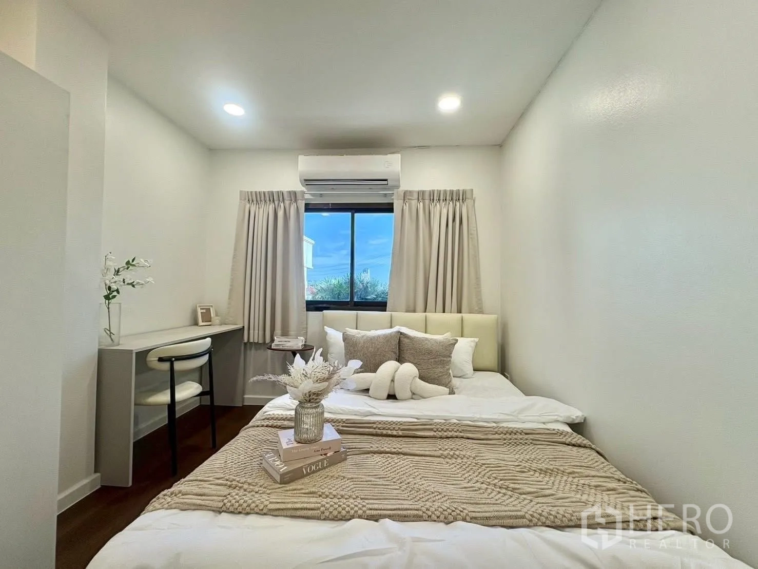 Townhouse for rent in Huai Khwang, Bangkok - Bedroom with double bed, desk, air conditioner, and curtained window.