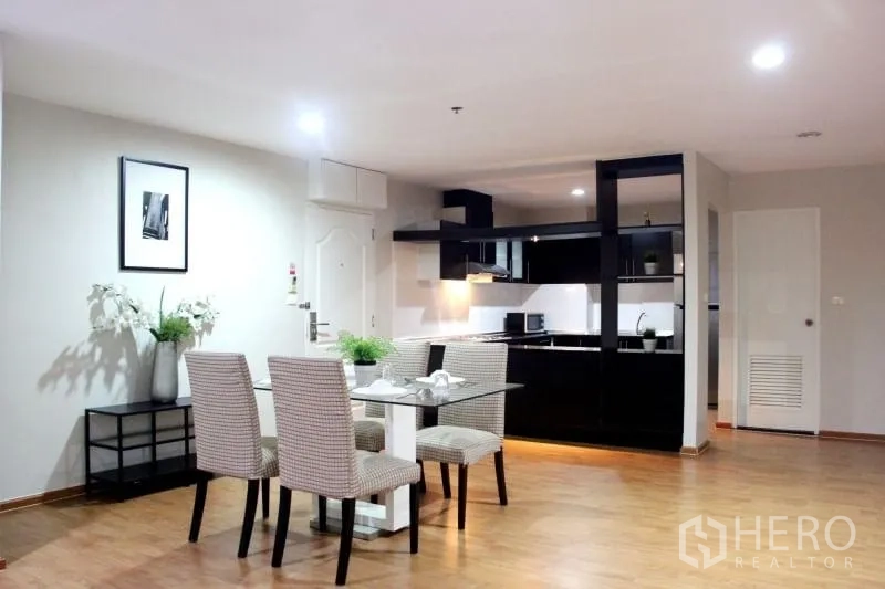 Condominium for rent in Khlong Toei, Bangkok - Wide lounge with central air vent, area rug, side tables and minimalist decor.