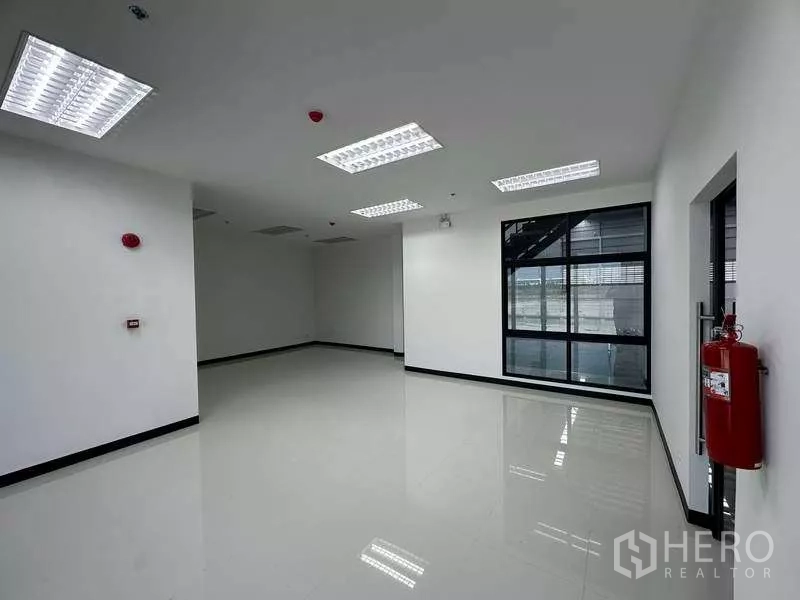 货栈 出租在Chon Buri - 仓库内明亮的办公房，瓷砖地面与大窗户。