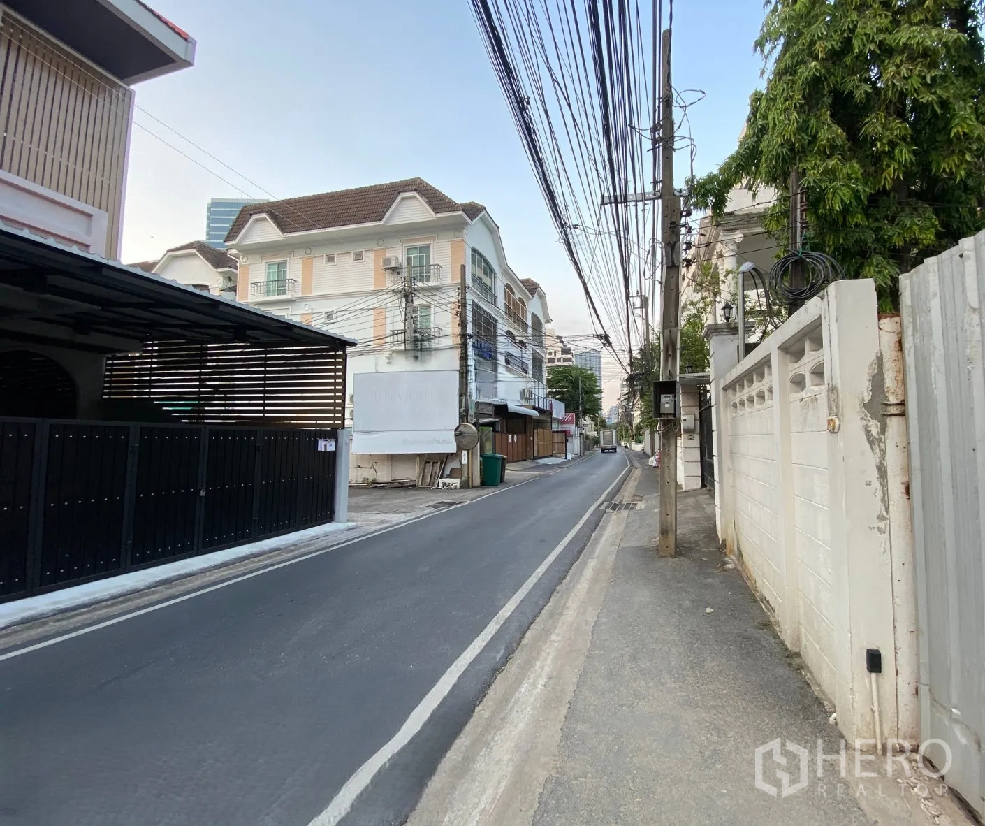 Land for rent in Phaya Thai, Bangkok - Quiet residential lane with sidewalk, utility poles, and low-rise buildings near the land.
