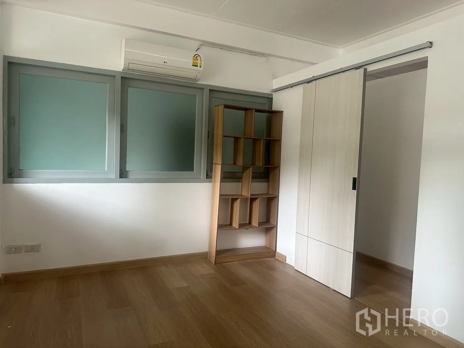Detached House for rent in Watthana, Bangkok - Bedroom with air-conditioner, sliding door and built-in shelf unit.