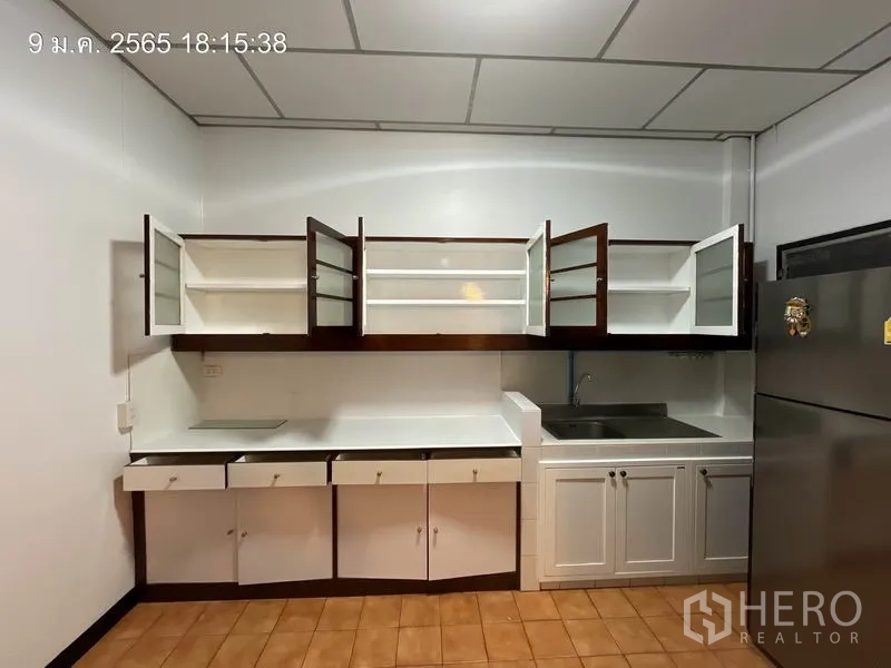 独立式住宅 出租在Khlong Toei, Bangkok - 明亮厨房，白色台面，玻璃门吊柜打开，配不锈钢水槽。