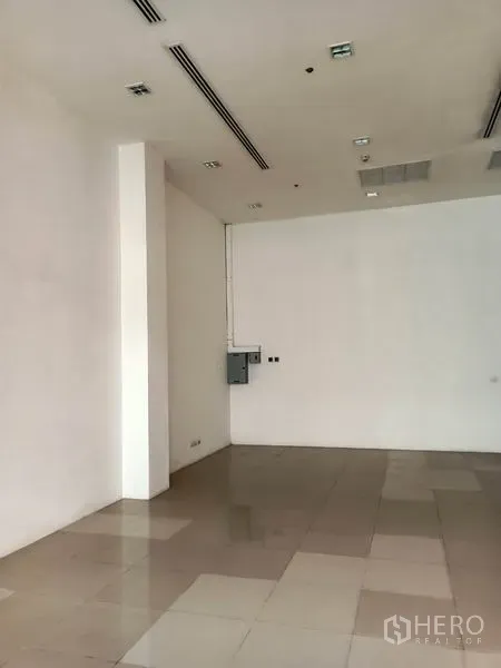 Retail Space for rent in Khlong Toei, Bangkok - Empty retail interior with high ceiling, recessed lighting and tiled flooring.