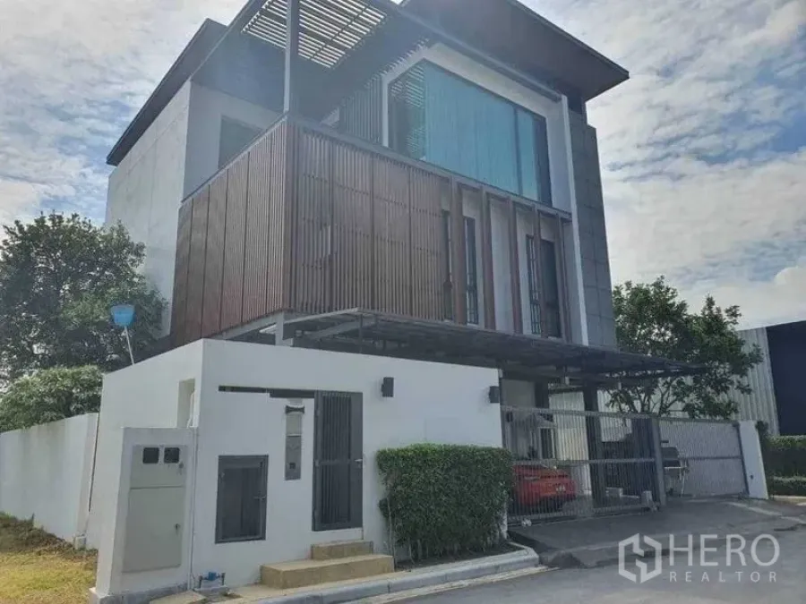 Detached House for rent or sale in Prawet, Bangkok - Modern three-storey detached house on a corner plot with gated entrance and carport.