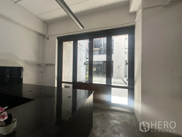 Home Office for rent in Pathum Wan, Bangkok - Bright workspace with large floor-to-ceiling windows and sleek black service counter.