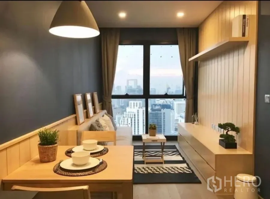 公寓 出租在Watthana, Bangkok - 开放式起居区，小巧餐桌与通高窗，城市景观一览无余。