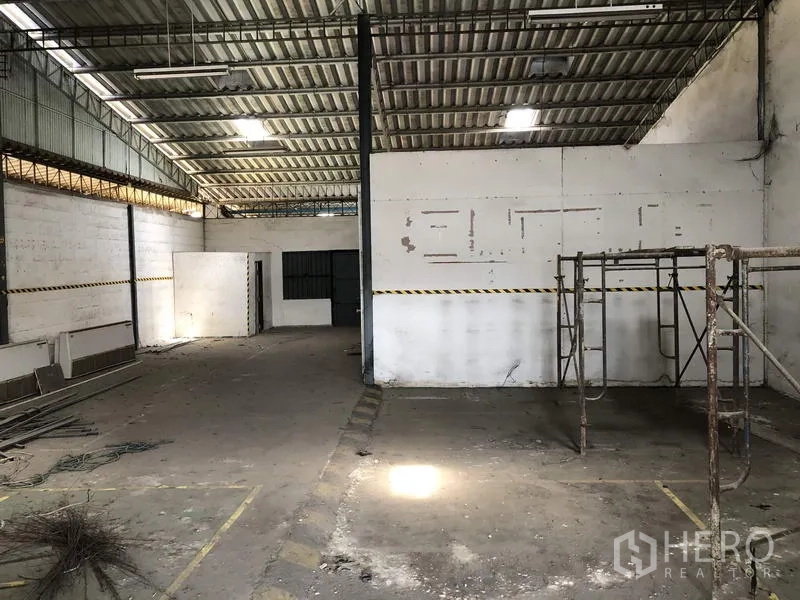 Warehouse for rent in Khlong Luang, Pathum Thani - Workshop area with partitions, scaffolding and industrial lighting.