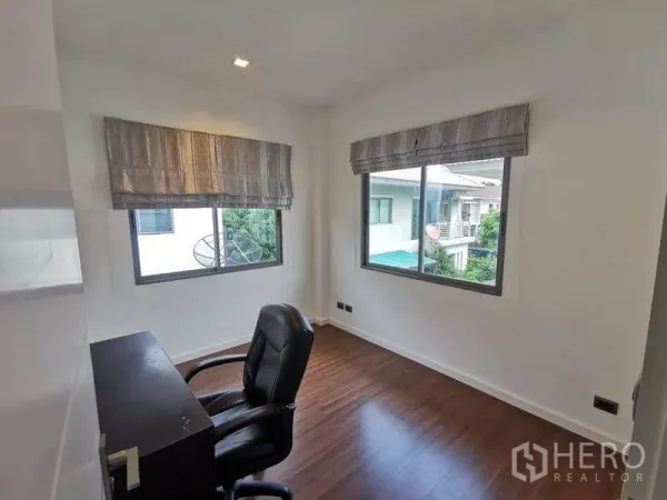 Detached House for rent in Prawet, Bangkok - Bright home office with two windows, desk and leather chair on wood flooring.