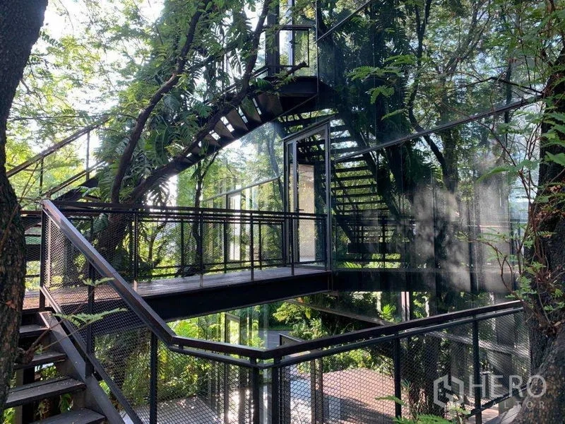 Office Space for rent in Khlong Toei, Bangkok - Multi-level steel staircases and bridges surrounding a modern glass structure in greenery.