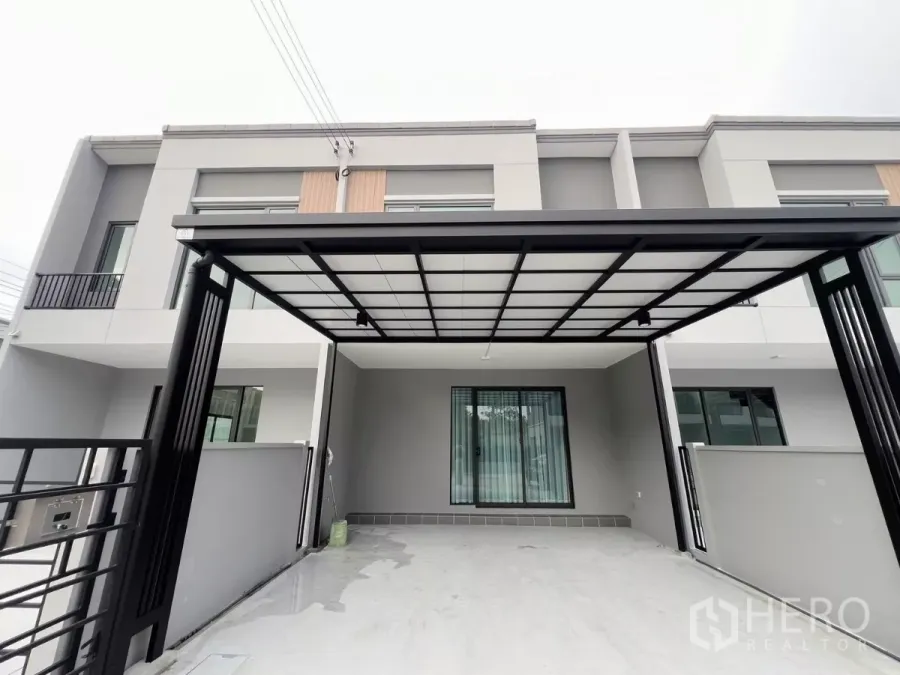 Townhouse for rent in Bang Phli, Samut Prakan - Modern two-storey townhouse facade with covered carport and sliding gate