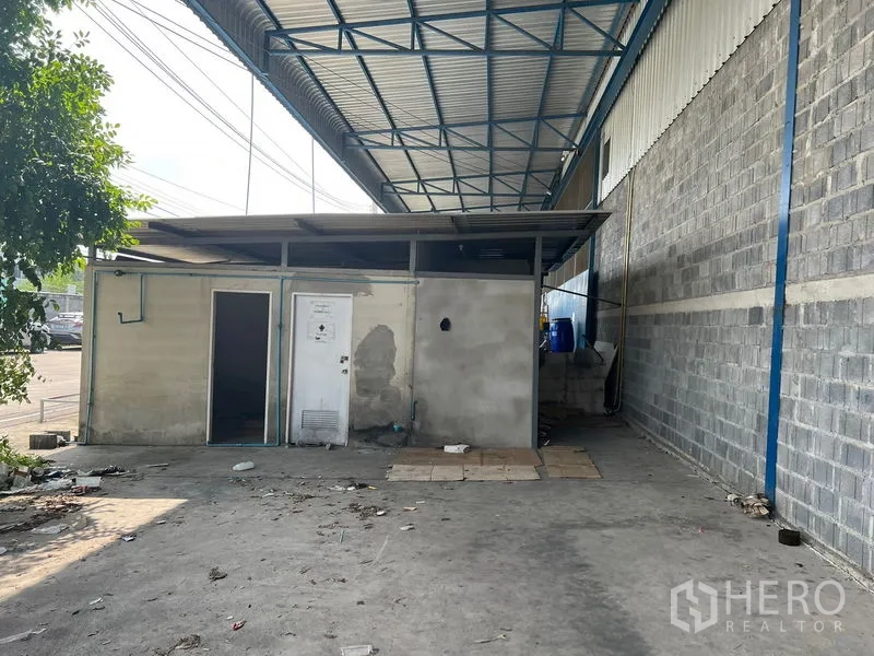 Warehouse for rent in Lat Krabang, Bangkok - Covered loading area beside the warehouse with a small utility room.