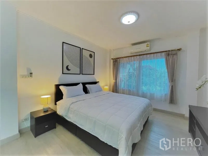 Detached House for rent in Suan Luang, Bangkok - Airy master bedroom with large bed, bedside tables, air conditioner and wide window.