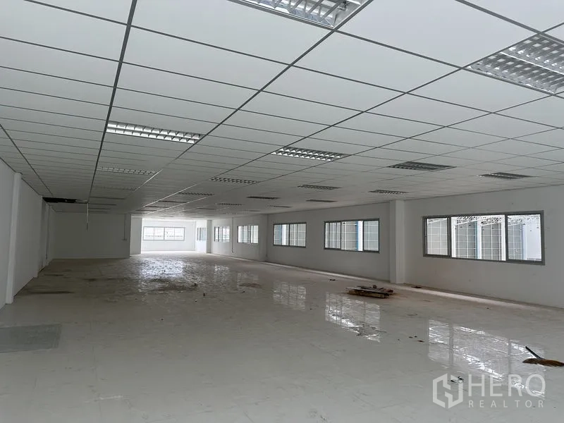 工厂 出租在Pathum Thani - 开放式办公区，侧墙多窗，瓷砖地面。