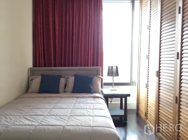 Condominium for rent in Khlong Toei, Bangkok - Cozy bedroom with double bed, red curtains and louvered wooden wardrobes