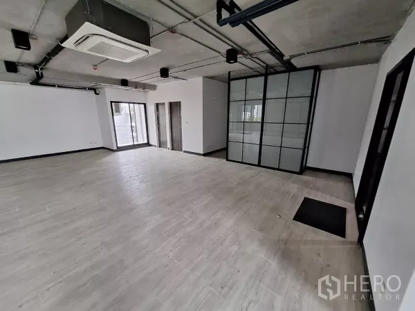 Office Space for rent in Watthana, Bangkok - Office corner showing cassette air conditioner, sliding door to balcony, and grid glass partition.