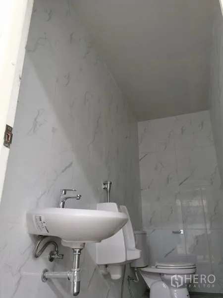 Factory for rent in Chon Buri - Clean tiled restroom with sink, urinal and toilet in industrial building.