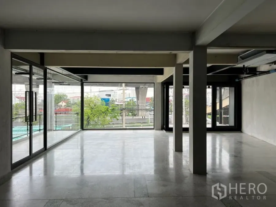 Retail Space for rent - Open-plan retail interior with floor-to-ceiling windows, polished floors and city views toward the BTS line, ready for fit-out.