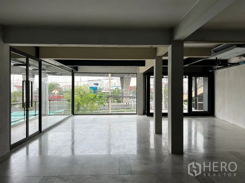 Retail Space for rent - Open-plan retail interior with floor-to-ceiling windows, polished floors and city views toward the BTS line, ready for fit-out.