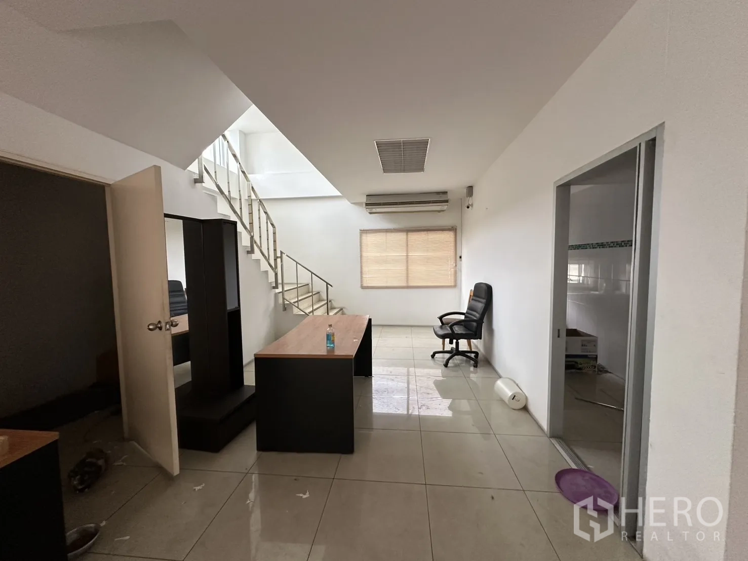Factory for rent - Office interior with tiled floors, staircase, desks, and air-conditioning.