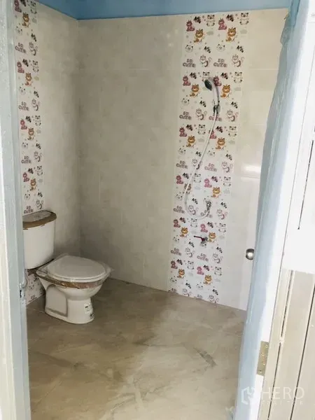 Warehouse for rent in Bang Kapi, Bangkok - Second tiled restroom with toilet and shower, light-colored walls and floor.