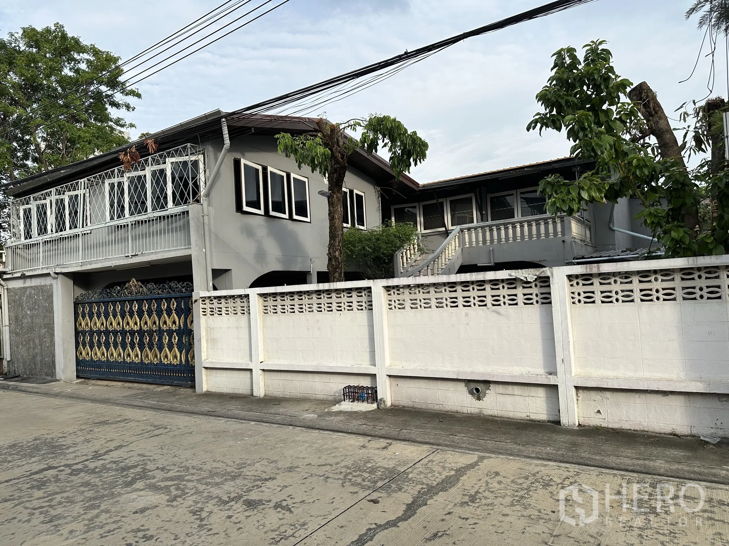 家庭办公室 for rent in Suan Luang, Bangkok - 两层办公住宅外观，白色围墙、阳台与绿树。