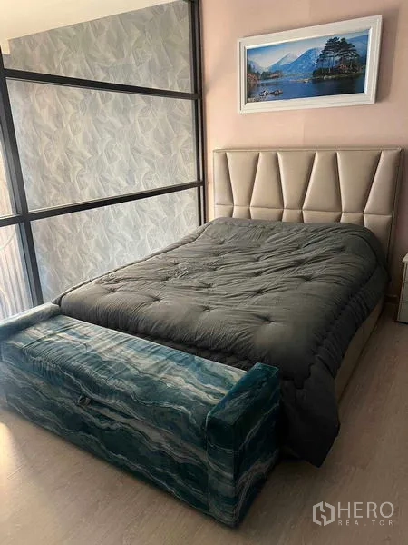 Condominium for rent in Khlong Toei, Bangkok - Mezzanine bedroom with an upholstered headboard, bench and glass partition overlooking the living area.