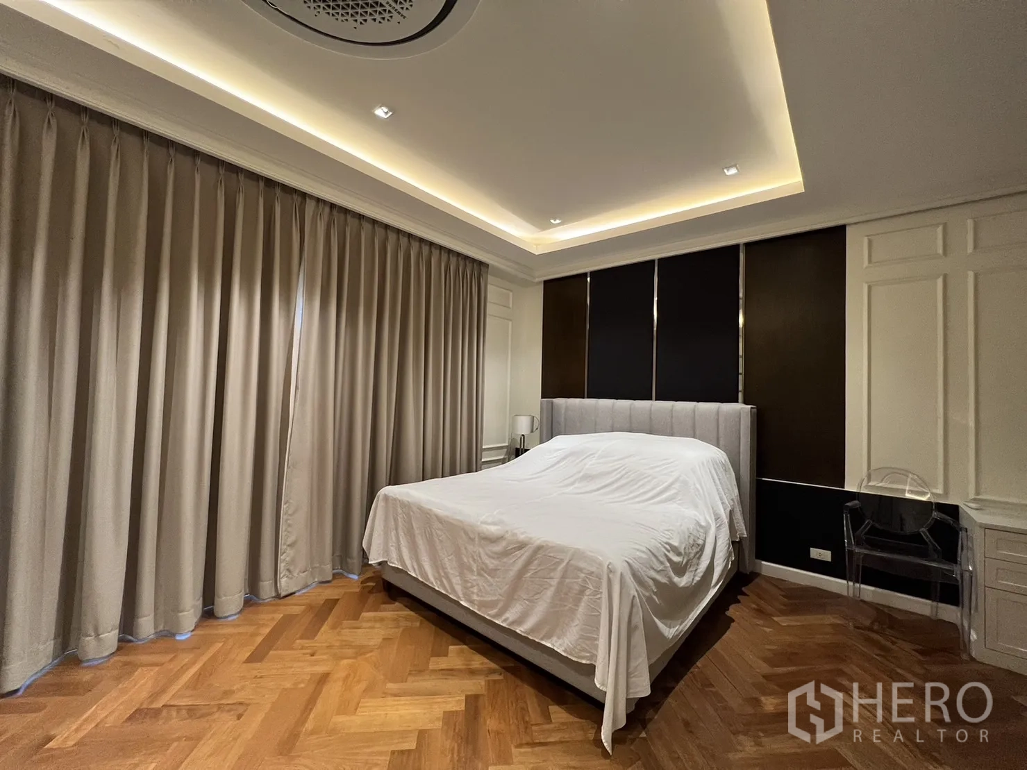 独立式住宅 出租在Suan Luang, Bangkok - 卧室配软包床、深色背景墙与窗帘。