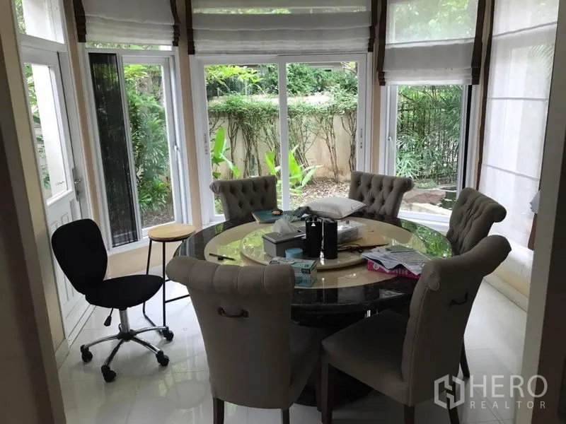 Detached House for rent in Bang Khen, Bangkok - Bay-window dining nook with round table and upholstered chairs overlooking the garden.