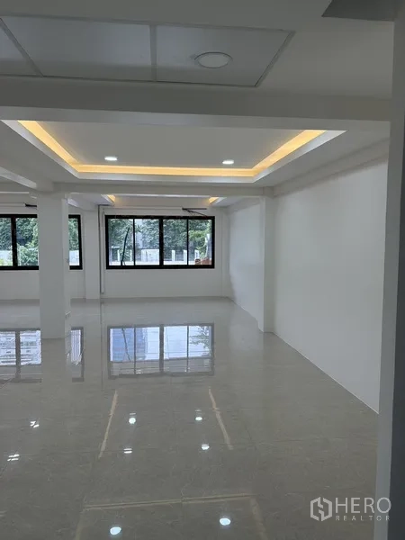 Office Space for rent or sale in Huai Khwang, Bangkok - Workspace zone with cove lighting ceiling and green views through windows.