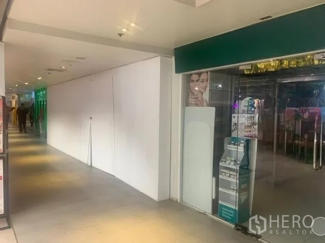 Retail Space for rent - Retail shopfront location beside a glass-fronted store within a covered shopping passage.