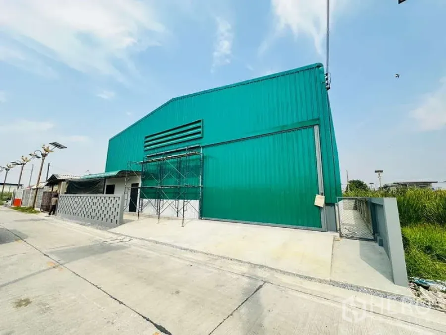 货栈 出租在Bang Phli, Samut Prakan - 绿色仓库正立面，超大滑动门，车道与门禁出入口便于车辆进出。
