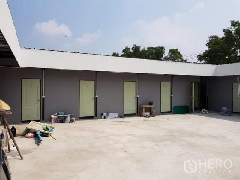Warehouse for sale in Lam Luk Ka, Pathum Thani - Courtyard lined with individual doors to staff rooms or utility units.