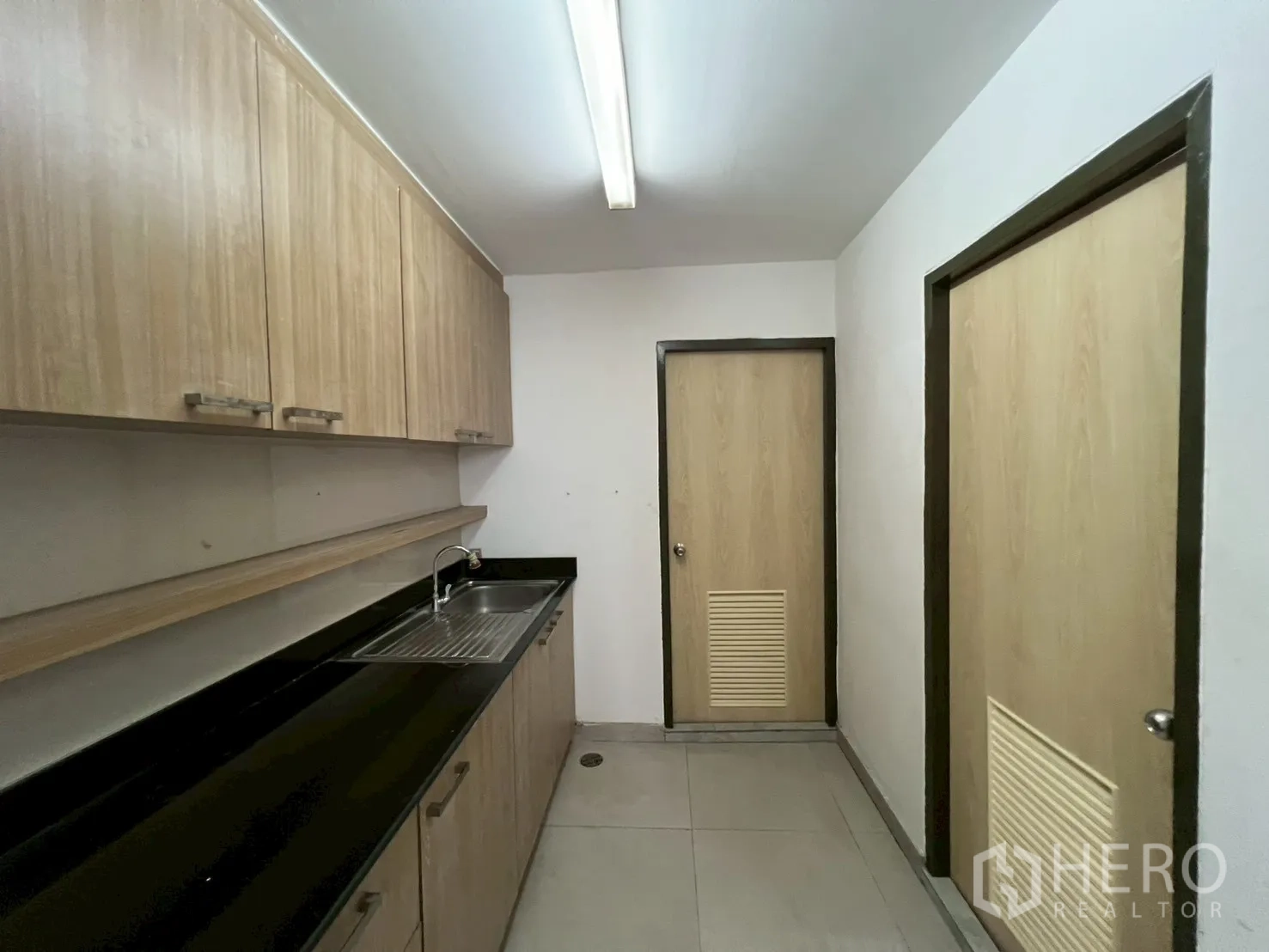 Office Space for rent in Watthana, Bangkok - Built-in office pantry with upper cabinets, sink and black countertop.