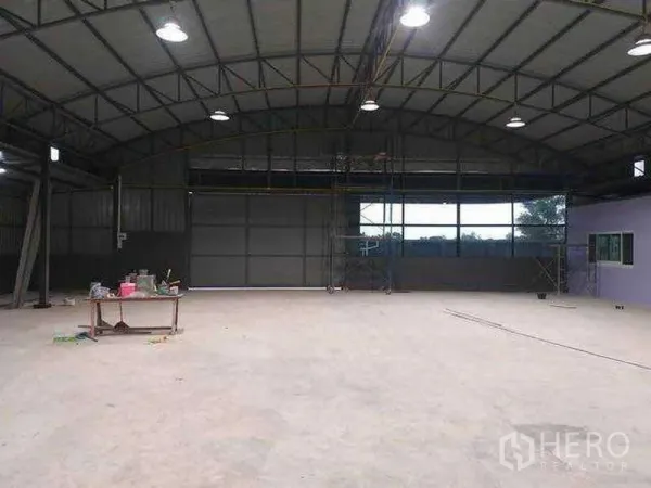 Warehouse for rent in Khlong Sam Wa, Bangkok - Open‑plan warehouse interior with high arched steel roof, windows and bright high‑bay lights.