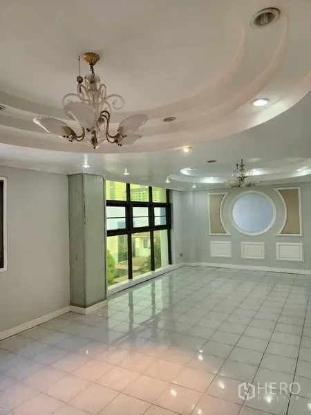 Office Space for rent or sale in Khlong Toei, Bangkok - Bright lobby or meeting room with chandeliers, white tiled floor, and decorative wall paneling.