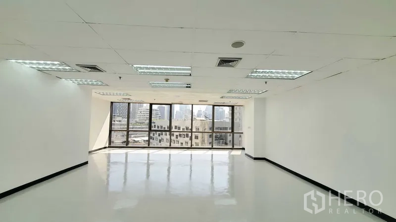 Office Space for rent in Watthana, Bangkok - Bright open-plan office with large windows, city views, glossy floors, and suspended ceiling lights in Watthana, Bangkok.