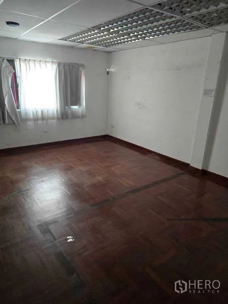 Shophouse for rent in Watthana, Bangkok - Bright room with parquet wood floor and window, ideal for office or studio.