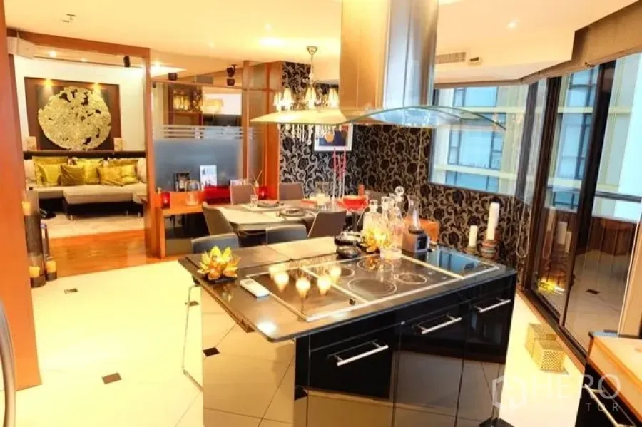 Condominium for sale in Pathum Wan, Bangkok - Modern kitchen with island cooktop, stainless hood and dining area by tall windows.