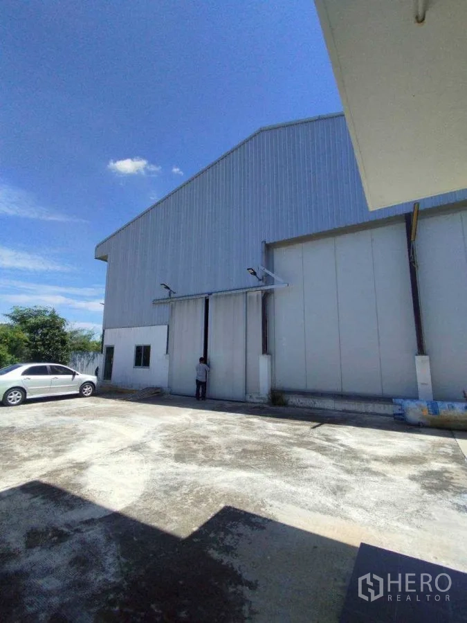 工厂 for rent or sale in Mueang Nakhon Pathom, Nakhon Pathom - 金属外墙厂房外观，超大推拉门与宽阔停车场地。