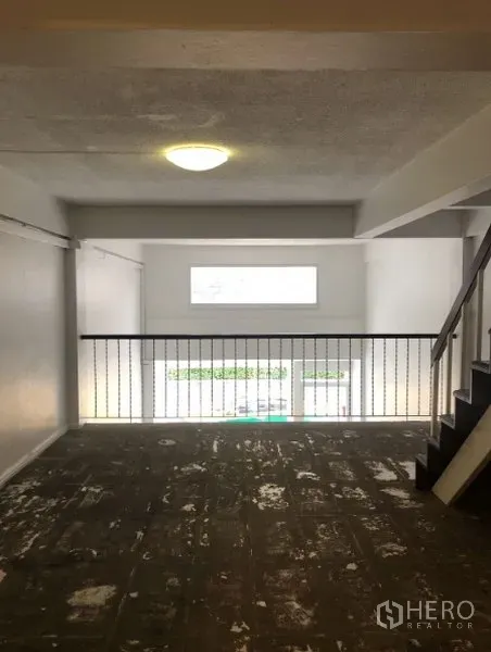 Shophouse for rent in Watthana, Bangkok - Open-plan mezzanine level with railing and window for natural light.