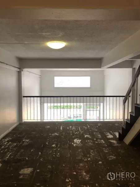 Shophouse for rent in Watthana, Bangkok - Open-plan mezzanine level with railing and window for natural light.
