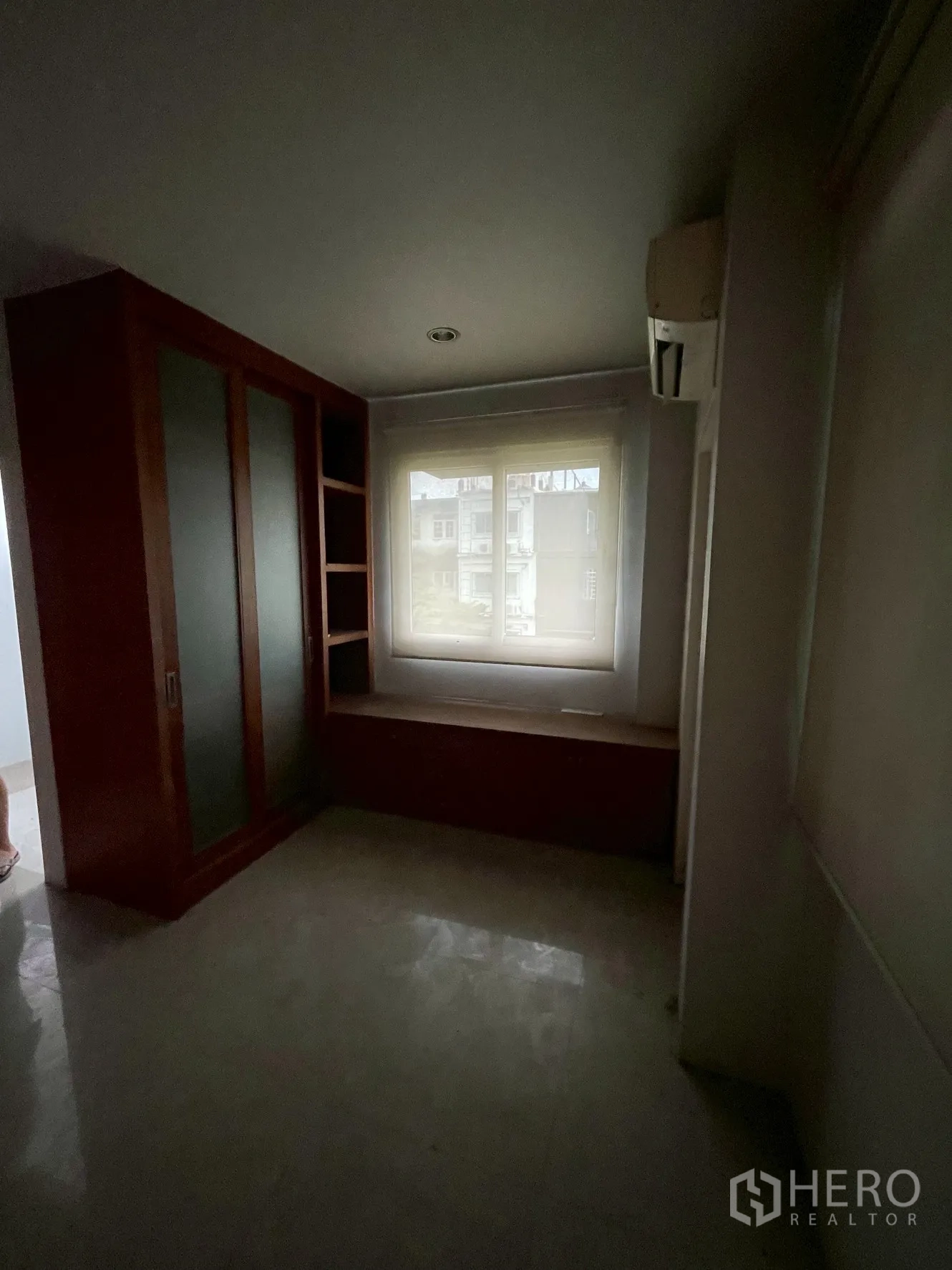 Home Office for rent in Wang Thonglang, Bangkok - Compact room with wardrobe, window seat and frosted cabinet doors.